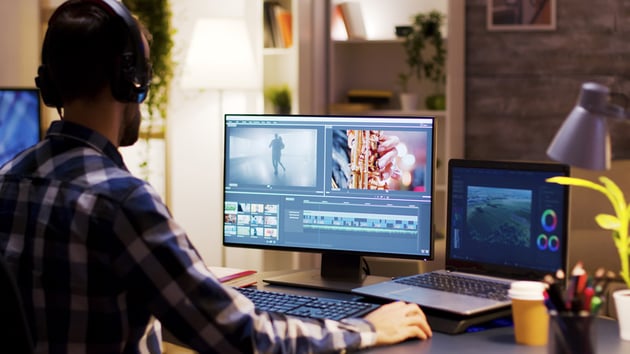 filmmaker sat at desk editing